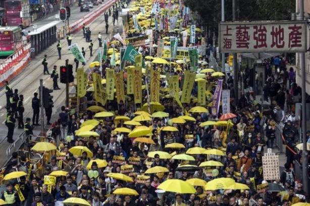 Thousands of pro-democracy protesters hold up yellow umbrellas, symbols of the Occupy Central movement, during a march in the streets to demand universal suffrage in Hong Kong